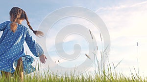 Child girl a dancing in the field park. Happy childhood family friendship concept. Girl kid whirls in a blue dress in