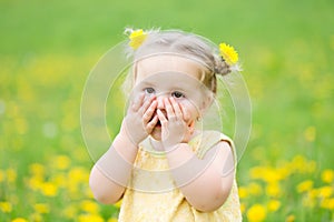 Child girl between dandelions