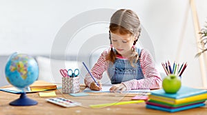 Child girl doing homework writing and reading at home photo