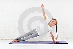 Child girl doing yoga and gymnastics in gym