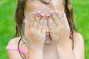 Child girl don`t see, covering her eyes and face by hands