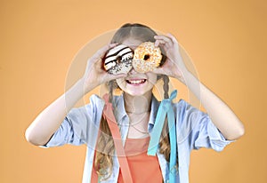 Child girl with donut eyes happysmiling face. Kid have fun,entertainment. Good mood concept. Person with sweet food