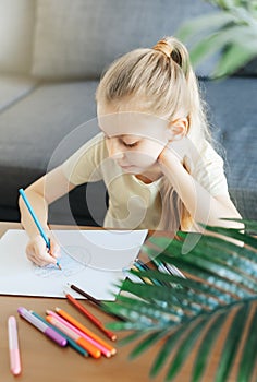 Child girl drawing with colorful pencils