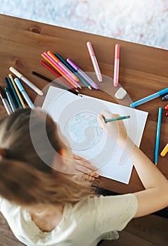 Child girl drawing with colorful pencils