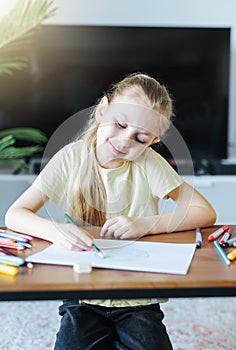 Child girl drawing with colorful pencils