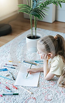 Child girl drawing with colorful pencils