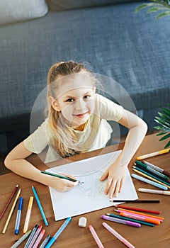 Child girl drawing with colorful pencils