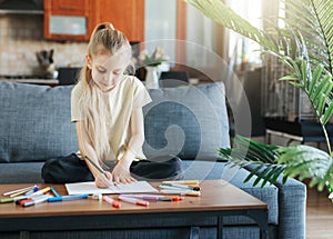 Child girl drawing with colorful pencils