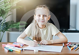 Child girl drawing with colorful pencils