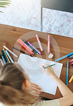 Child girl drawing with colorful pencils