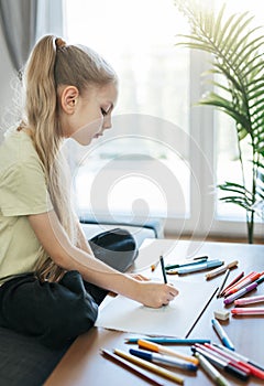 Child girl drawing with colorful pencils