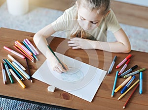 Child girl drawing with colorful pencils