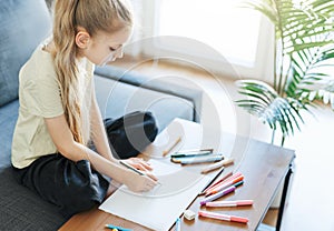 Child girl drawing with colorful pencils