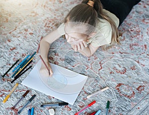 Child girl drawing with colorful pencils