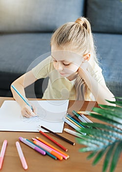 Child girl drawing with colorful pencils