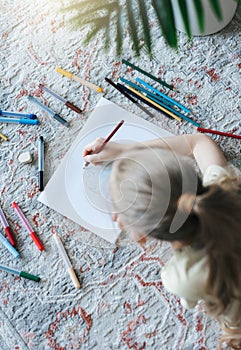 Child girl drawing with colorful pencils