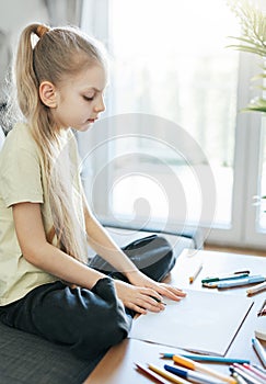 Child girl drawing with colorful pencils