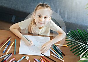 Child girl drawing with colorful pencils