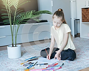 Child girl drawing with colorful pencils