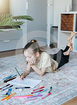 Child girl drawing with colorful pencils