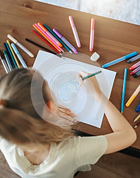 Child girl drawing with colorful pencils