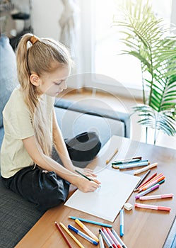 Child girl drawing with colorful pencils