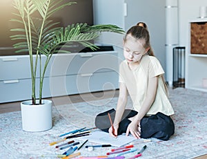 Child girl drawing with colorful pencils