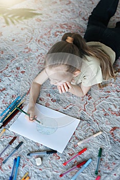 Child girl drawing with colorful pencils