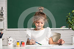 Child girl drawing with coloring pens paintind. Portrait of adorable little girl smiling happily while enjoying art and