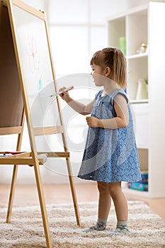 Child girl drawing at home
