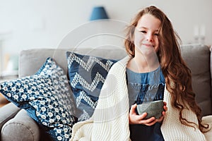 child girl drinking hot tea to recover from flu photo