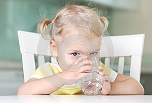 Child girl drinking water from glass closeup portrait