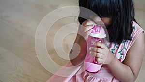 child girl drinking water sitting on sofa