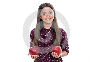 Child girl eating an apple over isolated white studio background. Tennager with fruit. Portrait of happy funny smiling