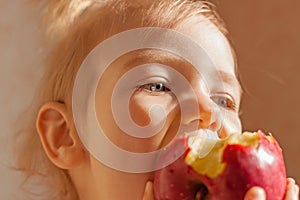 Child girl eating big red apple