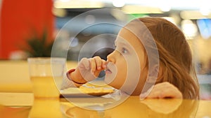 Child girl eating fast food french fries in a cafe. Portrait closeup.