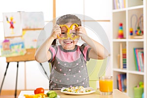 Child girl eating vegan food having fun in kindergarten