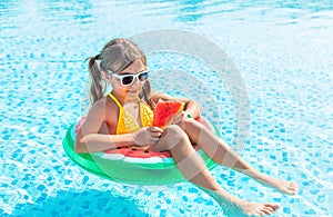 Child girl eats watermelon near the pool. Selective focus.