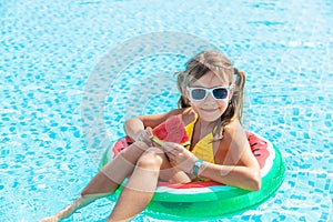 Child girl eats watermelon near the pool. Selective focus.