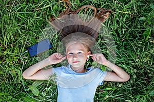 Child Girl Enjoying Music in Green Meadow