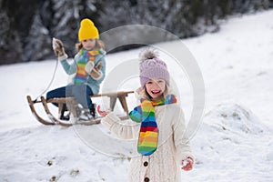 Child girl enjoying snow ball play outdoors. Kids sled in the Alps mountains in winter. Outdoor fun for family christmas
