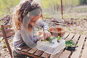 Child girl exploring nature in early spring forest. Kids learning to love nature. Teaching children about seasons changing.