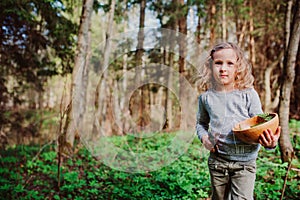 Child girl exploring nature in early spring forest. Kids learning to love nature. Teaching children about seasons changing.