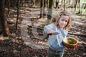 Child girl exploring nature in early spring forest. Kids learning to love nature. Teaching children about seasons changing.