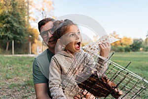 Child girl with father portrait outdoors with grill bbq net with beef steak meat. Happy family weekend at the backyard