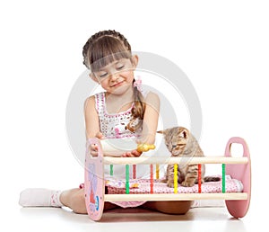 Child girl feeding and playing kitten cat