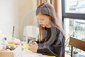 Child Girl Focused on Easter Egg Decorating