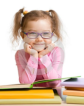 Child girl in glasses reading book and smiling