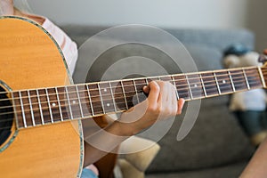 Child girl hand playing guitar in room - leisure music and hobby concept