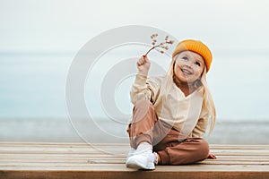Child girl happy smiling outdoor walking on the beach kid 4 years old in yellow hat family travel